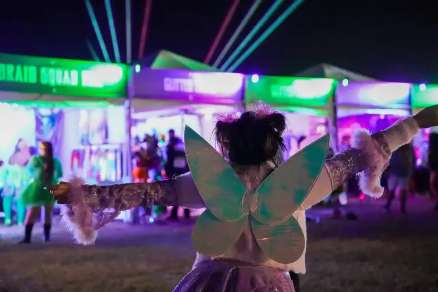 Festival goer in costume under stage lights